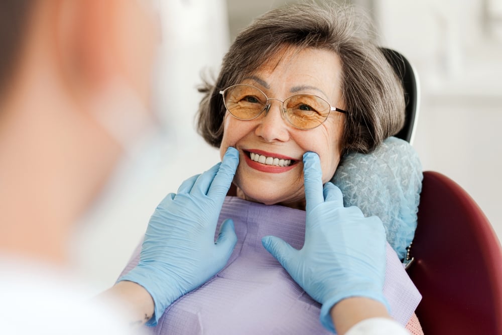 Smiling older lady at the dentist with dental implants